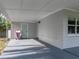 Interior of the carport showing the access doors on one wall with neutral paint at 1140 W Seminole Trl, Bartow, FL 33830