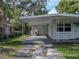 Side view of the carport showing a walkway with stones, decorative post, and access doors at 1140 W Seminole Trl, Bartow, FL 33830