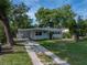 Charming home features mature trees, a well-kept lawn, and a convenient carport for covered parking at 1140 W Seminole Trl, Bartow, FL 33830