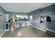 Stylish living space with bar stool seating connecting to a kitchen featuring white cabinets and stainless appliances at 1140 W Seminole Trl, Bartow, FL 33830