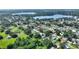 A scenic aerial view of a property nestled among trees in a tranquil neighborhood, nearby lake in the distance at 118 Browning Cir, Winter Haven, FL 33884