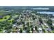 A lush aerial view of the property surrounded by trees in a residential neighborhood, nearby lake in the distance at 118 Browning Cir, Winter Haven, FL 33884