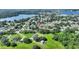 An aerial view of the property surrounded by mature trees, with a view of the nearby lake at 118 Browning Cir, Winter Haven, FL 33884