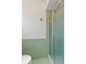 Bathroom featuring green tiling, white wainscotting and glass door shower at 118 Browning Cir, Winter Haven, FL 33884