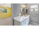 Bright bathroom featuring white cabinets, large mirror and cheerful decor at 118 Browning Cir, Winter Haven, FL 33884