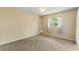 Bedroom with neutral carpet, tan walls, window, and full length mirror at 118 Browning Cir, Winter Haven, FL 33884