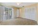 Bedroom with neutral carpet, tan walls, closet, and glass sliding door leading to a screened in porch at 118 Browning Cir, Winter Haven, FL 33884