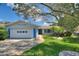 Charming single-story home featuring a well-manicured lawn, mature trees, and a two-car garage at 118 Browning Cir, Winter Haven, FL 33884
