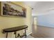 Inviting entryway with console table and artwork, leading to a bright, open living area with hardwood floors at 118 Browning Cir, Winter Haven, FL 33884