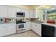 Well-lit kitchen featuring stainless steel appliances, white cabinets, and ample counter space for meal preparation at 118 Browning Cir, Winter Haven, FL 33884