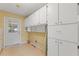 Laundry room featuring tile floors and ample storage with lots of white cabinets at 118 Browning Cir, Winter Haven, FL 33884