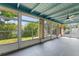 Enclosed sunroom featuring a ceiling fan and large windows showcasing lush greenery and natural light at 118 Browning Cir, Winter Haven, FL 33884