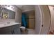 Tiled bathroom featuring a shower with blue curtain and a vanity with grey cabinets at 12241 Augusta Woods Cir, Orlando, FL 32824