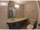 Simple bathroom features a vanity with blue cabinets, a large mirror, and a toilet at 12241 Augusta Woods Cir, Orlando, FL 32824