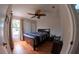 Comfortable bedroom with ceiling fan, wood floors, and a large window at 12241 Augusta Woods Cir, Orlando, FL 32824