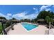 Community pool with lounge chairs, pool umbrellas and well-maintained landscaping at 12241 Augusta Woods Cir, Orlando, FL 32824