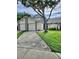 Charming two-story home with a spacious driveway, lush lawn, and mature trees providing shade at 12241 Augusta Woods Cir, Orlando, FL 32824