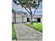 Charming two-story home with a spacious driveway, lush lawn, and mature trees providing shade at 12241 Augusta Woods Cir, Orlando, FL 32824