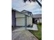 Two-story home featuring a two-car garage, small tiled walkway, and manicured front lawn at 12241 Augusta Woods Cir, Orlando, FL 32824