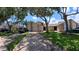 Wide shot of a townhome exterior and driveway, showing mature trees, lush lawn and ample parking at 12241 Augusta Woods Cir, Orlando, FL 32824