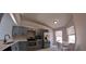 Modern kitchen with stainless steel appliances, sleek gray cabinetry, and bright dining area at 12241 Augusta Woods Cir, Orlando, FL 32824