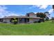Back of the property showing the screened in porch and green lawn at 12241 Augusta Woods Cir, Orlando, FL 32824