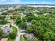A lovely aerial view showcases a beautiful community with mature trees and a nearby lake at 125 Homewood Dr, Winter Haven, FL 33880