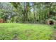 The expansive, green backyard features mature trees, offering privacy and a serene outdoor space at 125 Homewood Dr, Winter Haven, FL 33880