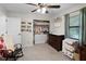 Bright bedroom with a rocking chair, ceiling fan, and organized closet at 125 Homewood Dr, Winter Haven, FL 33880