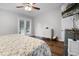 Bright bedroom with French doors, a ceiling fan, wood floors, and a dresser at 125 Homewood Dr, Winter Haven, FL 33880