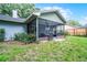 The backyard features a screened-in patio, which has a gray concrete floor and a black metal screen at 125 Homewood Dr, Winter Haven, FL 33880