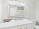 Bathroom vanity featuring marble counters, a large mirror, and updated fixtures at 14191 Se 25Th Ave, Summerfield, FL 34491