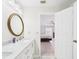 Bright bathroom featuring marble countertops, gold-trimmed mirrors, and an open door at 14191 Se 25Th Ave, Summerfield, FL 34491