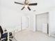 Bright bedroom features an open closet, tile floors, and a ceiling fan at 14191 Se 25Th Ave, Summerfield, FL 34491