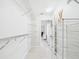 Spacious walk in closet with white shelving and light tile floors at 14191 Se 25Th Ave, Summerfield, FL 34491