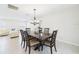 This dining room features a chandelier over a dark wood table and six chairs in a bright, white space at 14191 Se 25Th Ave, Summerfield, FL 34491