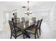 Bright dining room features a modern chandelier, white walls, and a large, dark wood dining table at 14191 Se 25Th Ave, Summerfield, FL 34491