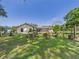 Exterior backyard view featuring lush greenery and a screened-in porch at 14191 Se 25Th Ave, Summerfield, FL 34491