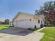 A view of the garage attached to this single story home. Long driveway and lush lawn at 14191 Se 25Th Ave, Summerfield, FL 34491