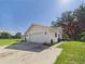A view of the garage attached to this single story home. Long driveway and lush lawn at 14191 Se 25Th Ave, Summerfield, FL 34491