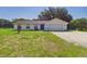 Charming single-story home with lush lawn, attached garage, and a long drive way at 14191 Se 25Th Ave, Summerfield, FL 34491