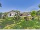 Exterior backyard with lush green lawn. Screened-in porch provides a peaceful retreat at 14191 Se 25Th Ave, Summerfield, FL 34491