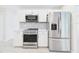 Kitchen area with stainless steel appliances, white cabinetry, and decorative backsplash at 14191 Se 25Th Ave, Summerfield, FL 34491