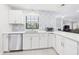 Modern kitchen with white cabinets, decorative backsplash, stainless steel appliances, and quartz countertops at 14191 Se 25Th Ave, Summerfield, FL 34491