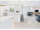 Open concept kitchen and dining area with modern white cabinets, tile backsplash, and eat-in island at 14191 Se 25Th Ave, Summerfield, FL 34491