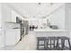 Eat-in kitchen featuring white cabinets, stainless steel appliances, an island, and decorative tile backsplash at 14191 Se 25Th Ave, Summerfield, FL 34491