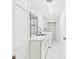 Bright laundry room with modern cabinets, patterned wall, sink, and washer/dryer units at 14191 Se 25Th Ave, Summerfield, FL 34491