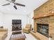 Bright living room with a brick fireplace, tile floors, and a comfortable seating arrangement at 14191 Se 25Th Ave, Summerfield, FL 34491