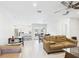 Bright living room features tile flooring, a ceiling fan, and an open layout to kitchen and dining areas at 14191 Se 25Th Ave, Summerfield, FL 34491