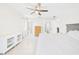 Bright main bedroom featuring tile floors, a ceiling fan, a walk in closet, an ensuite bathroom and white walls at 14191 Se 25Th Ave, Summerfield, FL 34491